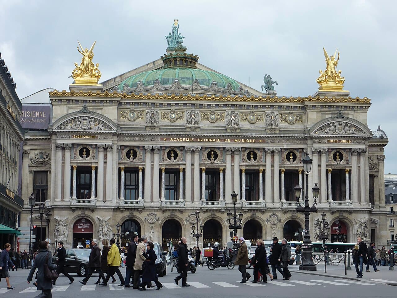 The ornate façade of the Palais Garnier opera house in Paris, decorated with columns, statuary and multicolored marble.