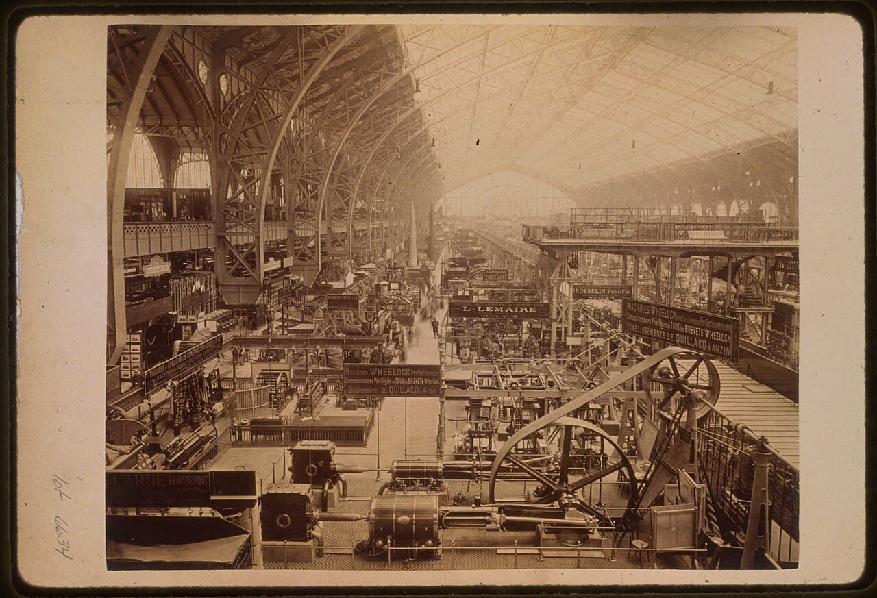 The vast iron-and-glass interior of the Galerie des Machines at the 1889 Paris Exposition, filled with industrial machinery on display.