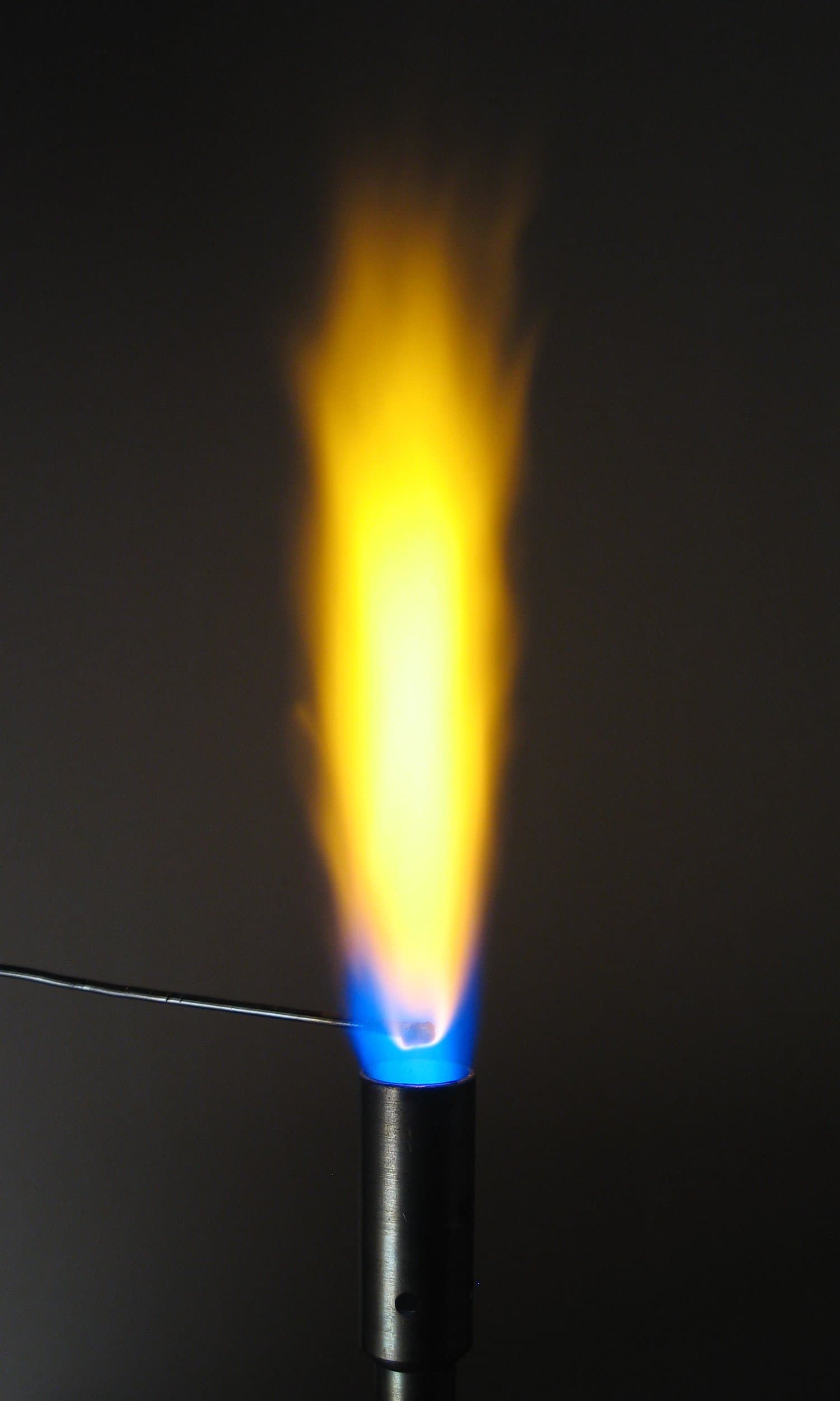 A burner flame glowing an intense bright yellow from a sodium flame test.