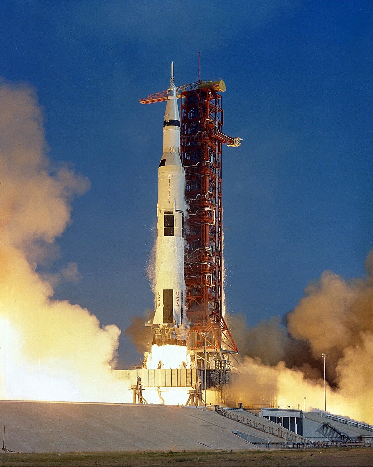 The Saturn V rocket launching Apollo 11, with flames and smoke billowing from its base.